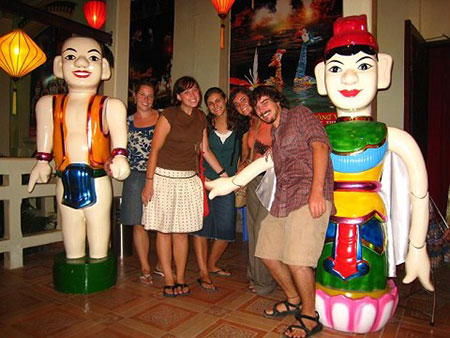 Tourists pose with water puppetry